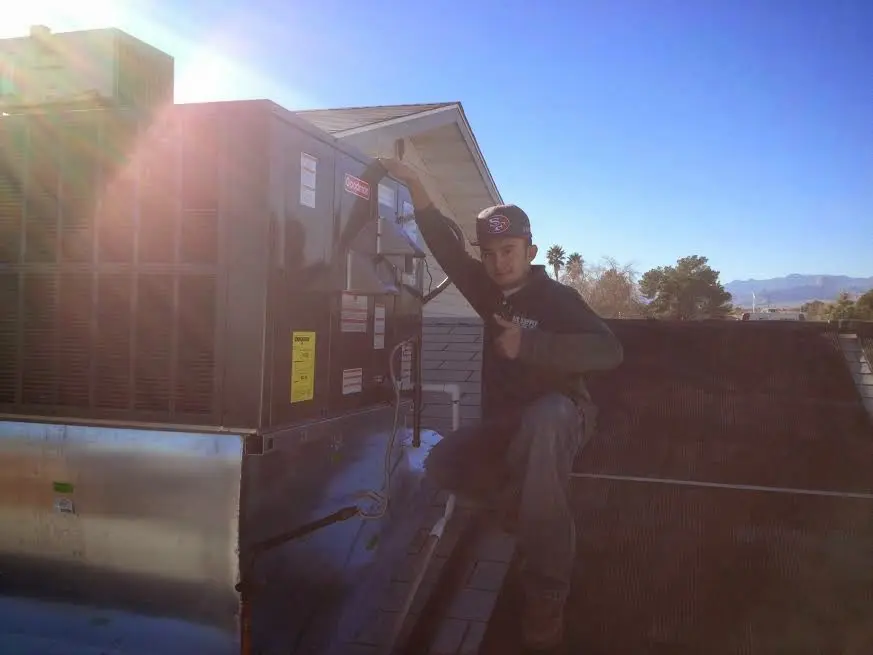 HVAC technician performing AC Tune-Up on a rooftop unit in Wilbraham