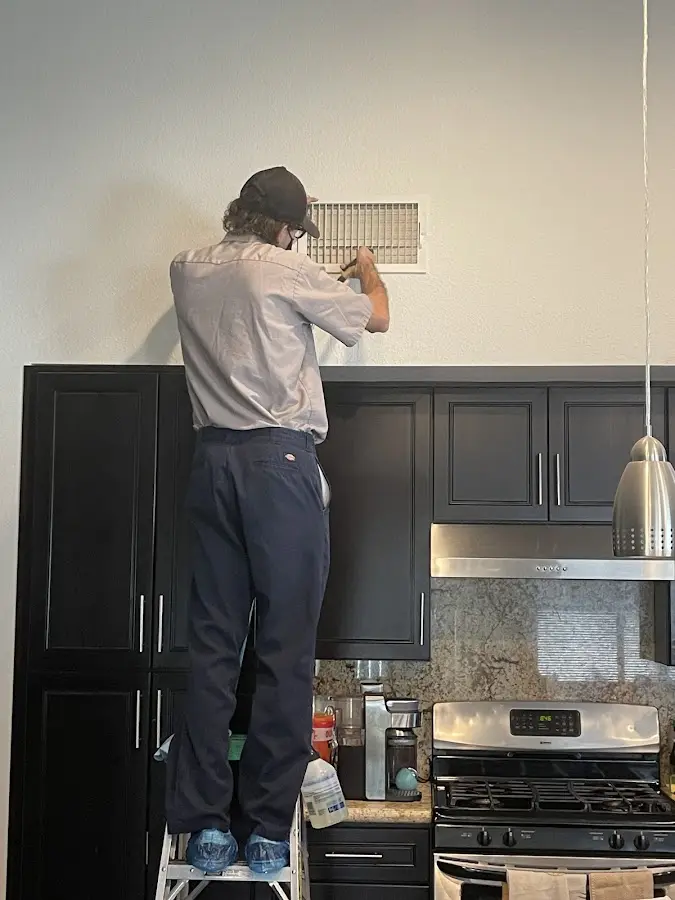 Technician inspecting an air vent during HVAC service in Wilbraham